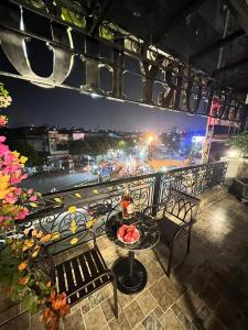 een tafel en stoelen op een balkon met uitzicht op de stad bij Victory Hotel in Hanoi