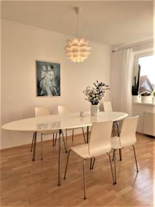 une salle à manger avec une table et des chaises blanches dans l'établissement Apartamenty Studio W Ustce - 120 m2 - 200 m od plaży Mickiewicza 2 35m2 z garażem ul Wczasowa 2, à Ustka