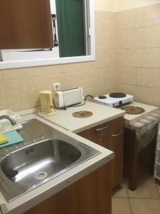 a kitchen with a sink and a stove at Meltemi Appartments in Perama