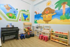 a childs room with a piano and a mural at 隨風旅行 親子包棟民宿 in Hengchun