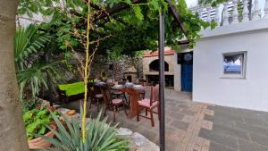 een terras met een houten tafel en stoelen bij Lukari Vacation Home in Drivenik