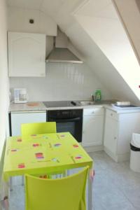une cuisine avec une table jaune et des chaises jaunes dans l'établissement Lumineux F2 proche GARE TGV, à Mulhouse