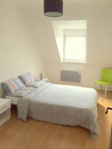 - une chambre avec un lit et une chaise verte dans l'établissement Lumineux F2 proche GARE TGV, à Mulhouse