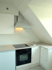 - une cuisine blanche avec évier et cuisinière dans l'établissement Lumineux F2 proche GARE TGV, à Mulhouse