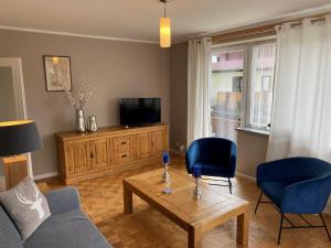 salon z kanapą, stołem i telewizorem w obiekcie Apartment Alpine by Apartment Managers w mieście Kirchberg in Tirol