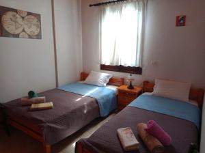 two twin beds in a room with a window at Aphrodite 's cottage in Milopotamos