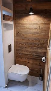a bathroom with a toilet and a wooden wall at Idéalement situé cœur du village - calme & confort in Saint-Étienne-de-Tinée