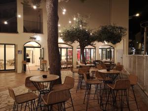 un restaurant avec des tables, des chaises et un arbre dans l'établissement EVENIA CORAL BOUTIQUE, à L'Estartit