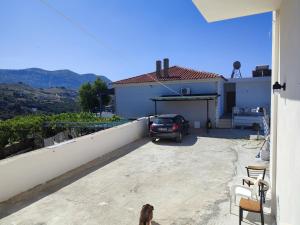 a dog sitting on the balcony of a house at Petros rooms in Himare