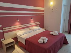 een slaapkamer met een bed met twee handdoeken erop bij Hotel La Punta in Otranto