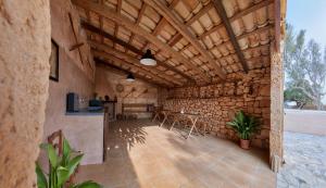 a stone walled room with a kitchen and a table at Ses cases noves Llucmajor in Llucmajor