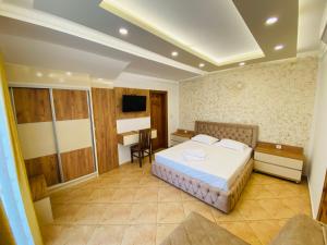 1 dormitorio con cama y escritorio. en Apart Hotel Llolla en Ulcinj