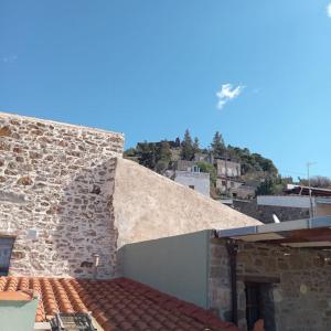a building with a stone wall and a roof at Παραδοσιακό πέτρινο σπίτι in Volissos