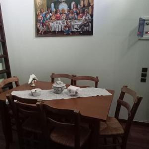 a dining room table with chairs and a painting on the wall at Παραδοσιακό πέτρινο σπίτι in Volissos
