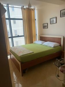Schlafzimmer mit einem Bett und einem großen Fenster in der Unterkunft MiMi's Beach Apartment in Vlorë