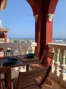 una mesa y una silla en un balcón con vistas al océano en Hispalis Mazagón Beach 304, en Mazagón