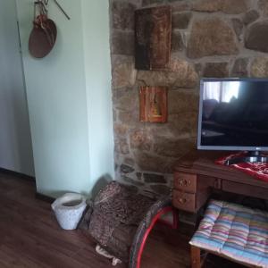 a tv sitting on a table next to a stone wall at Παραδοσιακό πέτρινο σπίτι in Volissos