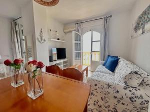a living room with a bed and a table with flowers on it at Hispalis Mazagón Beach 304 in Mazagón
