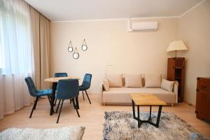 sala de estar con sofá, mesa y sillas en Orange by 3City Rentals en Sopot