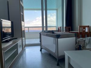 a living room with a television and a large window at Apartamentos Benivistas in Benidorm