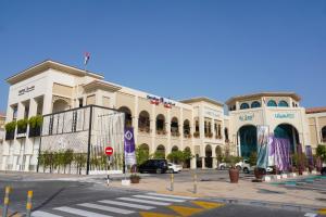 a large white building with a street in front of it at Andalus Al Seef Resort & Spa in Abu Dhabi