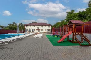 a playground with a slide and a swing set at Ранчо Офре in Solotvyno