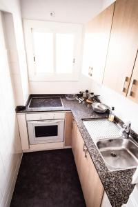 a small kitchen with a sink and a stove at Beach Lovers' Paradise, bright apartment for 2/3 in Vilanova i la Geltrú