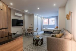 una sala de estar con un sofá y una mesa en La Malagueta by SharingCo - Estudios y apartamentos premium en Muelle uno, en Málaga