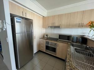 黃金海岸的住宿－Ocean View Apartment at the heart of Gold Coast，厨房配有不锈钢冰箱和水槽