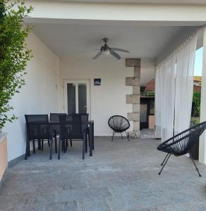 patio con mesa y sillas y ventilador de techo en Apartment "MANNA en Korčula