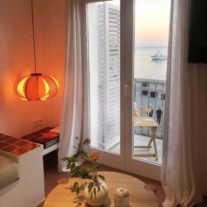a room with a large window with a view of the ocean at Beachfront SUITE in CADAQUES center in Cadaqués