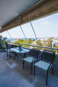 balcone con tavoli, sedie e vista di Endless Blue Studio in Glyfada ad Atene