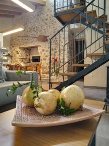 a plate of pears on a table with a staircase at Casa rural El Forn d'Alcudia de Veo in Alcudia de Veo