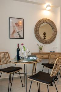 a dining room with a table and chairs and a mirror at Evora Suites in Chania Town