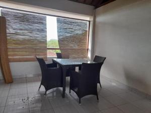 mesa y sillas en una habitación con ventana en Kutabay Homestay, en Kuta Lombok