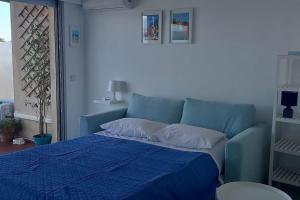 um sofá azul num quarto com uma cama azul em 06AT1 - Studio cosy bord de mer situation idéale em Antibes