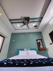 a bedroom with a bed with a ceiling fan at Srinivasa Homestay in Hampi