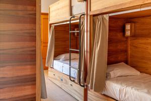 two bunk beds in a room with wooden walls at Lisbon Surf Hostel in Carcavelos