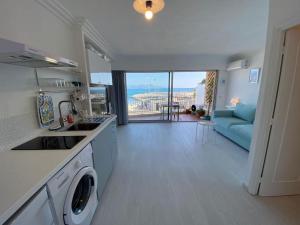uma cozinha e sala de estar com vista para o oceano em 06AT1 - Studio cosy bord de mer situation idéale em Antibes