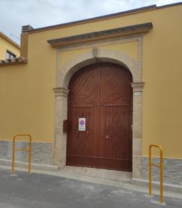 uma grande porta de madeira no lado de um edifício em Casa Cesa em Selargius