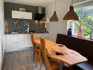 une cuisine avec une table en bois, des chaises et des lampes pendant dans l'établissement Apartment Haus Aktiv Garten, à Winterberg