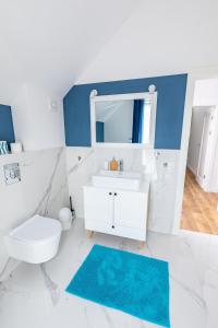ein weißes Bad mit einem Waschbecken und einem WC in der Unterkunft Szklane Domy ! in Junoszyno