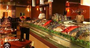 uma linha de buffet com muitos tipos diferentes de peixe em Lovely Sea View Apartment em Colombo