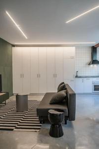 sala de estar con sofá de cuero y taburete en Balcon del Centro - BIGLIVING, en Vigo