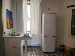 a kitchen with a refrigerator and a sink and a window at b&b Vallone del grano in Rossano