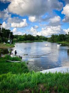 two people standing on the bank of a river at Viesu māja"Ordziņas" in Pāvilosta