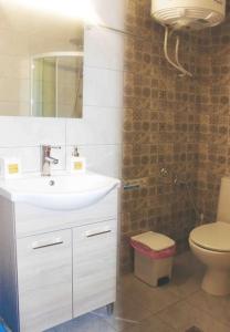 a bathroom with a sink and a toilet and a mirror at A&B My Sweet Home 1 in Ioannina +11 photos