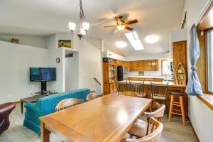 comedor y cocina con mesa de madera y sillas en Faribault Home with Deck Near Cedar Lake Boat Ramp!, en Faribault