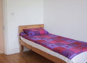 a bed with a colorful comforter in a room at Benbulben View Holiday Home in Drumcliff