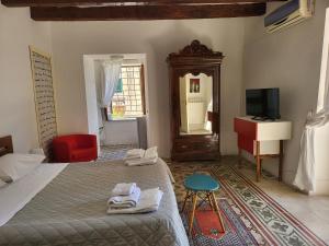 sypialnia z łóżkiem, telewizorem i czerwonym krzesłem w obiekcie b&b Vallone del grano w mieście Rossano